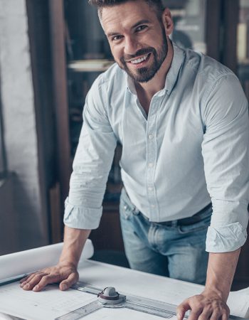 Smiling mature man with drawing in the workplace