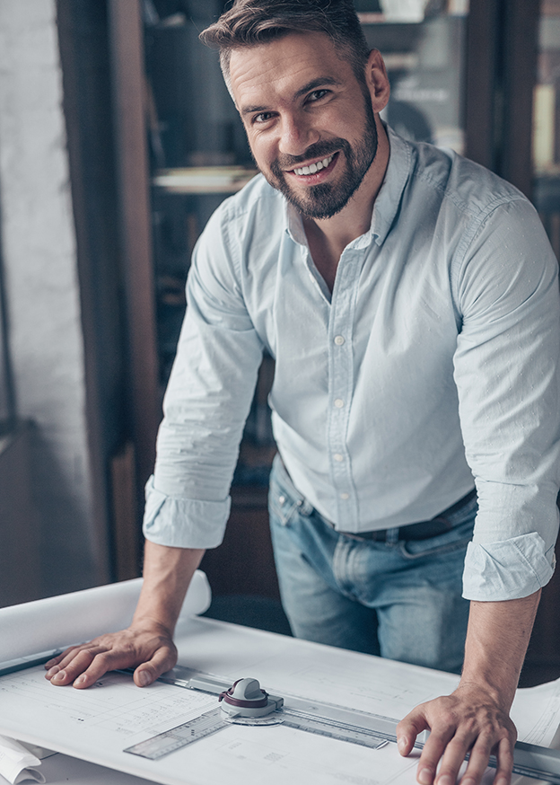 Smiling mature man with drawing in the workplace